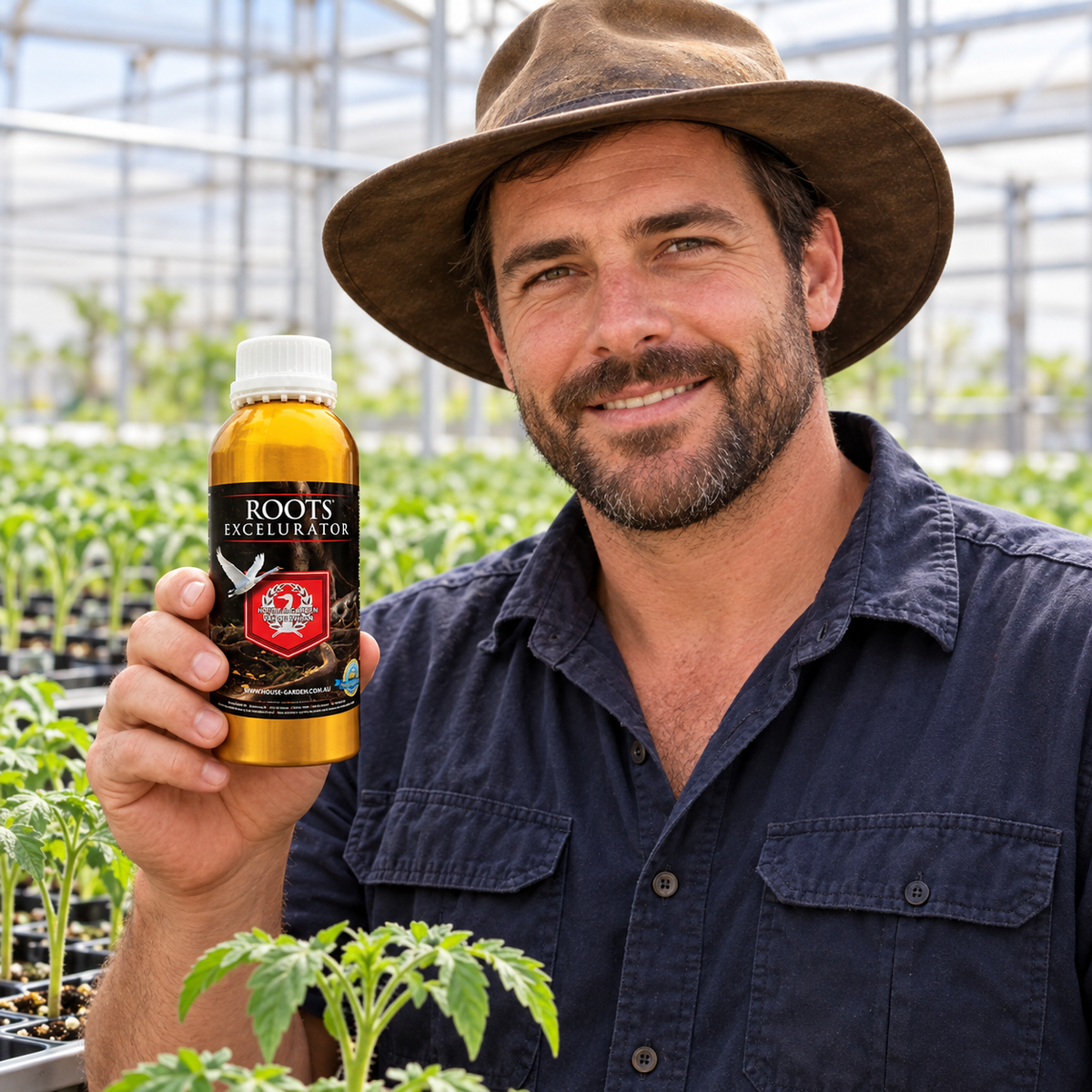 Adult Australian tomato greenhouse grower presenting a closed House & Garden Roots Excelurator 250mL bottle.