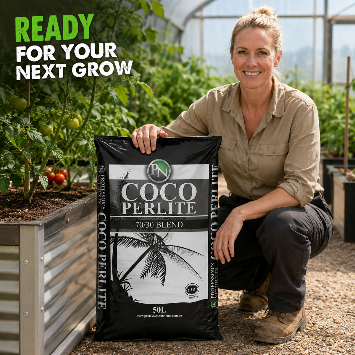 Adult Australian greenhouse grower presenting a 50L bag of Professors Coco Perlite beside tomato plants.